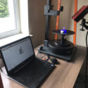 Skaner 3D modelujący obiekt na biurku obok laptopa z otwartym oprogramowaniem CAD